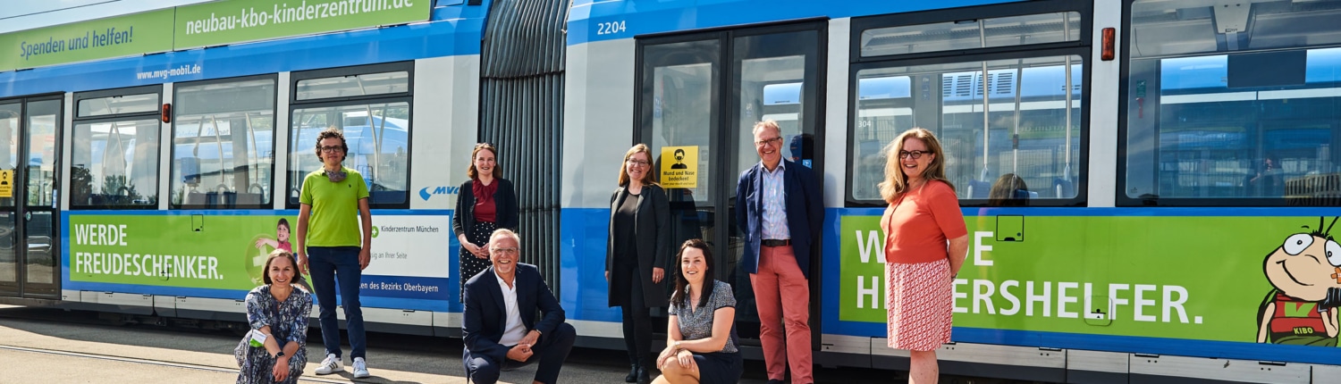 Hier ist das Team von Dietrich Identity abgebildet, wie es vor einen Trambahn steht.